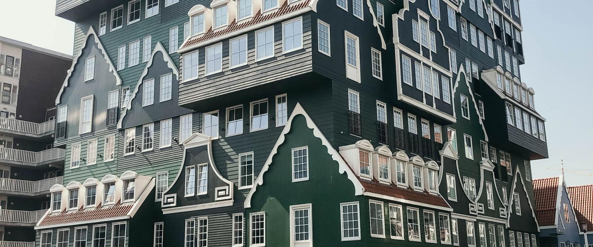 Explore the unique and colorful design of a modern Dutch-style building with a person admiring its architecture.