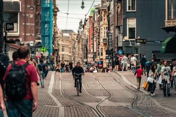 Vibrant Amsterdam street scene with cyclists and pedestrians, capturing the lively urban atmosphere.