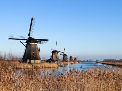 Scenic view of historic windmills along a canal in Kinderdijk, Netherlands.