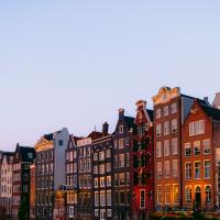Picturesque Amsterdam canal lined with iconic traditional houses during a serene sunset.