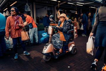 Vibrant outdoor market in The Hague with people shopping and socializing.