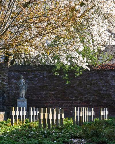 Tranquil memorial garden in Sittard, Limburg, Nederland surrounded by blooming trees in spring.