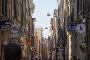 Explore a vibrant Amsterdam street showcasing historic buildings and lively city life, perfect for travel enthusiasts.